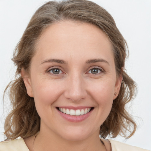 Joyful white young-adult female with medium  brown hair and blue eyes