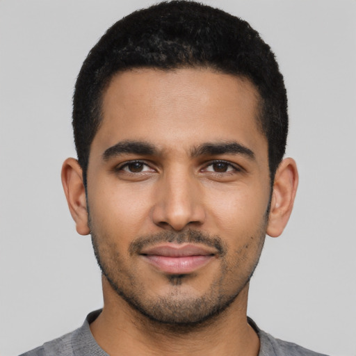 Joyful latino young-adult male with short  black hair and brown eyes