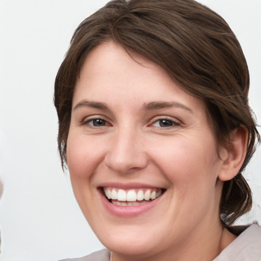 Joyful white young-adult female with medium  brown hair and grey eyes