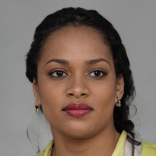 Joyful black young-adult female with medium  brown hair and brown eyes