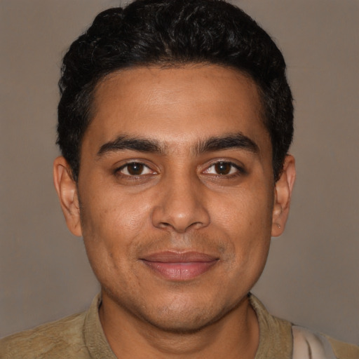 Joyful latino young-adult male with short  brown hair and brown eyes