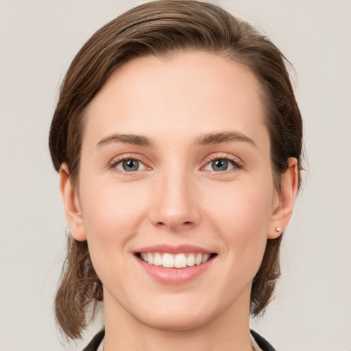 Joyful white young-adult female with medium  brown hair and grey eyes