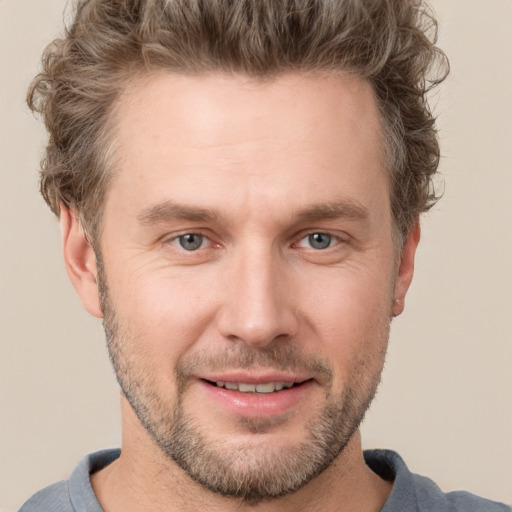 Joyful white adult male with short  brown hair and grey eyes