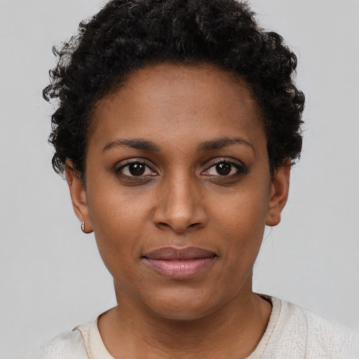 Joyful black young-adult female with short  brown hair and brown eyes