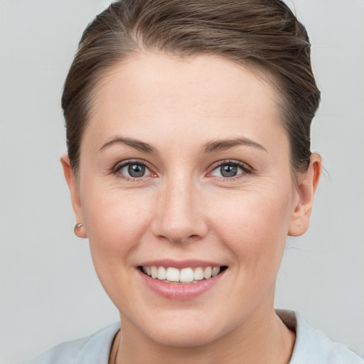 Joyful white young-adult female with short  brown hair and grey eyes