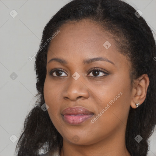 Joyful black young-adult female with long  brown hair and brown eyes