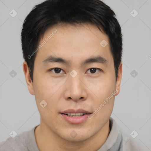 Joyful asian young-adult male with short  brown hair and brown eyes