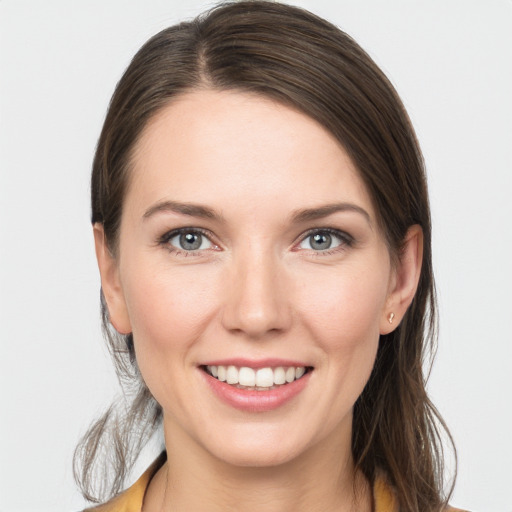 Joyful white young-adult female with long  brown hair and grey eyes