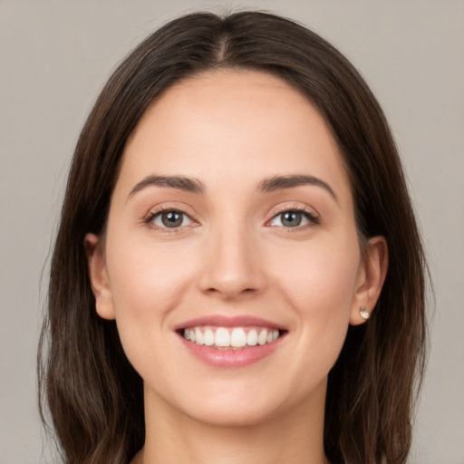 Joyful white young-adult female with long  brown hair and brown eyes