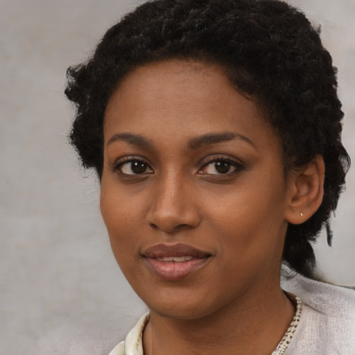 Joyful black young-adult female with short  brown hair and brown eyes