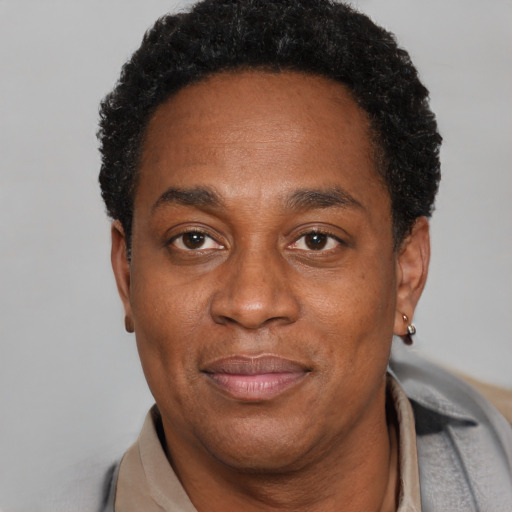 Joyful black adult male with short  black hair and brown eyes