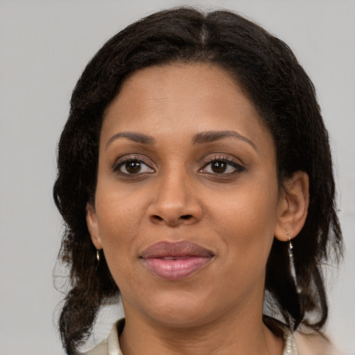 Joyful black adult female with medium  brown hair and brown eyes
