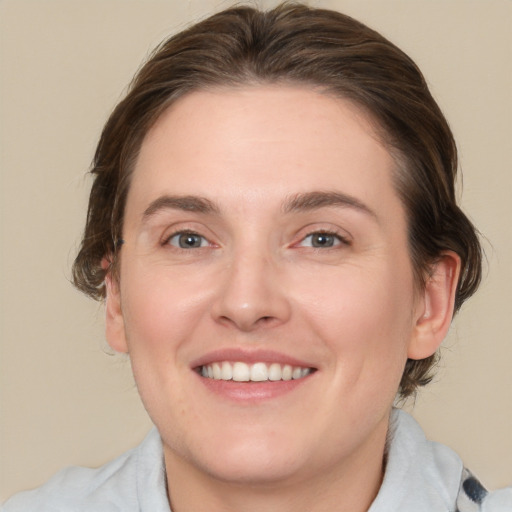 Joyful white young-adult female with medium  brown hair and blue eyes