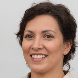 Joyful white adult female with medium  brown hair and brown eyes