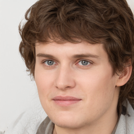 Joyful white young-adult male with medium  brown hair and grey eyes