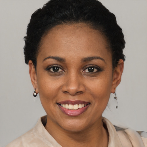 Joyful black young-adult female with short  black hair and brown eyes