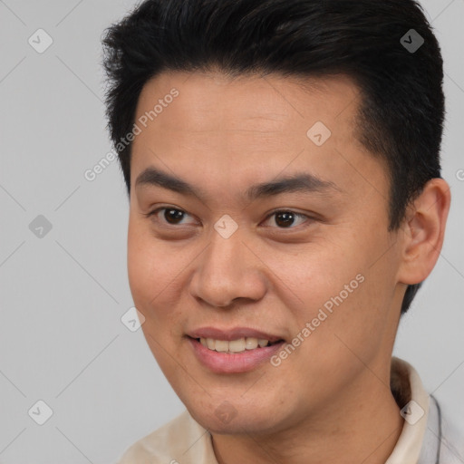 Joyful asian young-adult male with short  brown hair and brown eyes