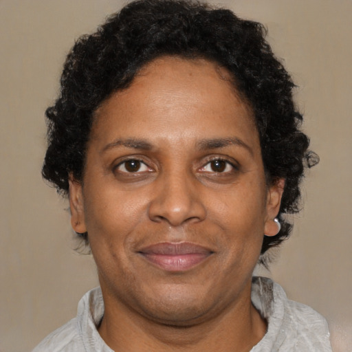 Joyful black adult female with short  brown hair and brown eyes