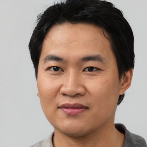 Joyful asian young-adult male with short  black hair and brown eyes
