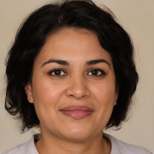 Joyful latino adult female with medium  brown hair and brown eyes