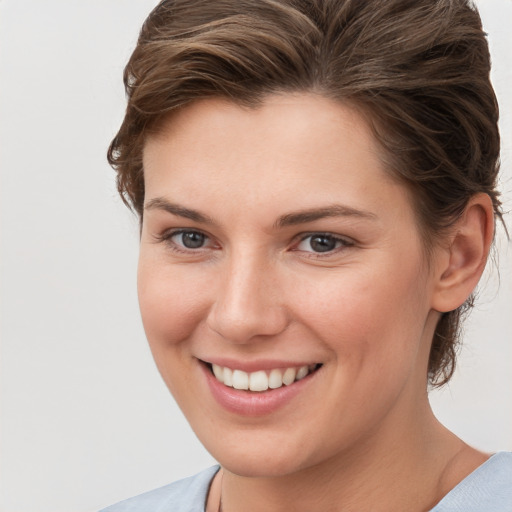 Joyful white young-adult female with medium  brown hair and grey eyes