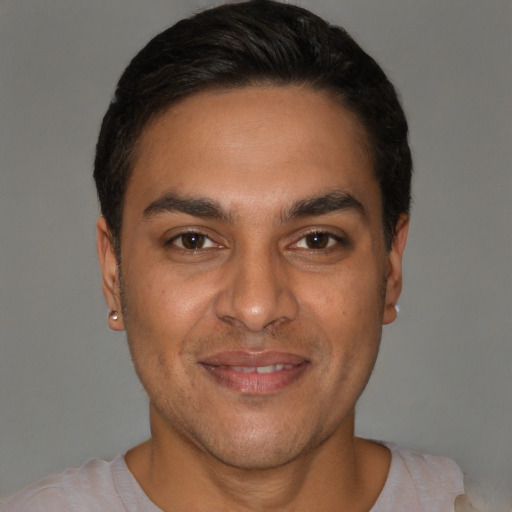 Joyful white young-adult male with short  black hair and brown eyes