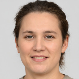 Joyful white young-adult female with medium  brown hair and grey eyes