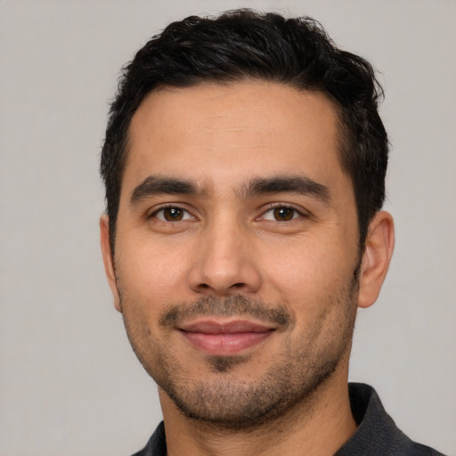 Joyful white young-adult male with short  black hair and brown eyes