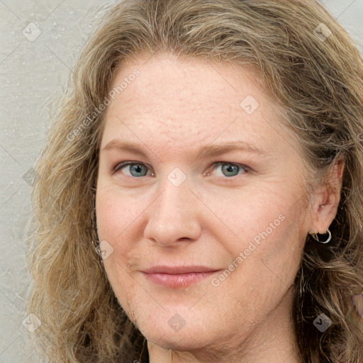 Joyful white adult female with long  brown hair and grey eyes