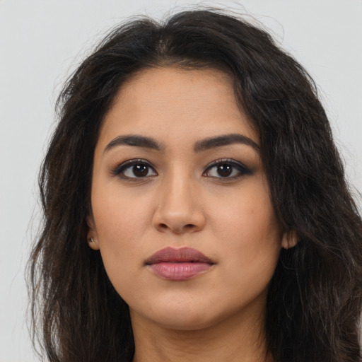 Joyful latino young-adult female with long  brown hair and brown eyes