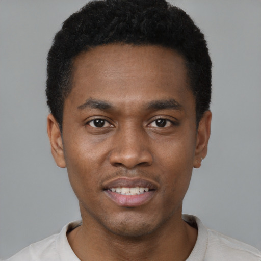 Joyful black young-adult male with short  black hair and brown eyes