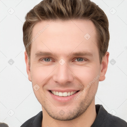 Joyful white young-adult male with short  brown hair and grey eyes