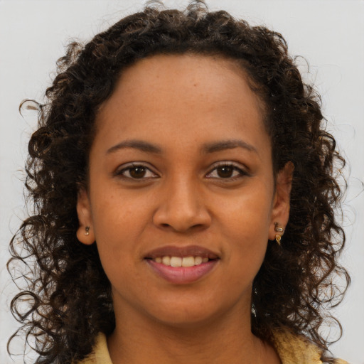 Joyful black young-adult female with long  brown hair and brown eyes