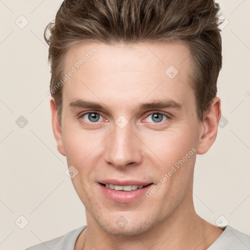 Joyful white young-adult male with short  brown hair and grey eyes