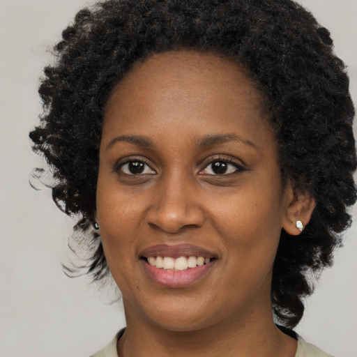 Joyful black young-adult female with medium  black hair and brown eyes