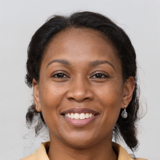 Joyful black adult female with medium  brown hair and brown eyes