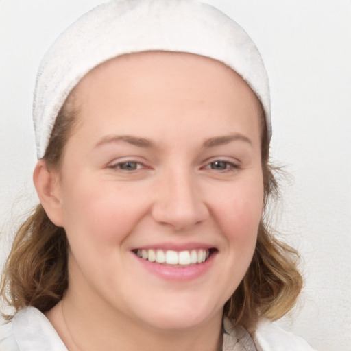 Joyful white young-adult female with medium  brown hair and blue eyes