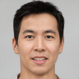 Joyful asian young-adult male with short  brown hair and brown eyes