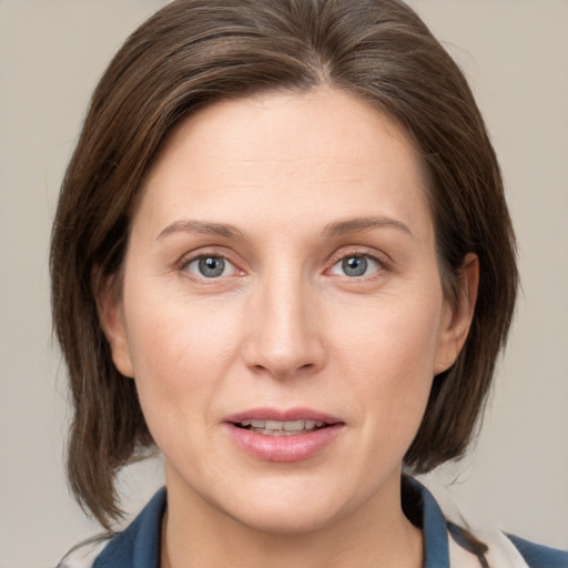 Joyful white young-adult female with medium  brown hair and grey eyes