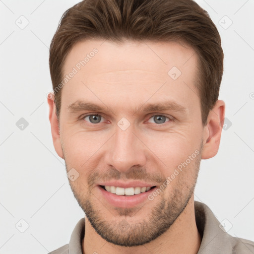 Joyful white young-adult male with short  brown hair and grey eyes