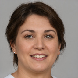 Joyful white adult female with medium  brown hair and brown eyes