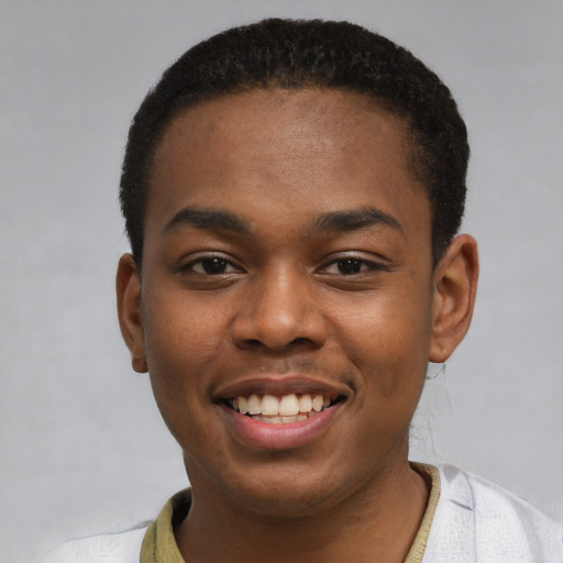 Joyful black young-adult male with short  brown hair and brown eyes