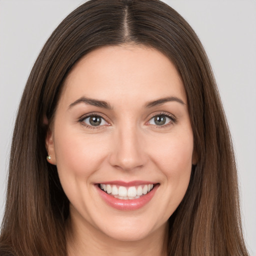 Joyful white young-adult female with long  brown hair and brown eyes