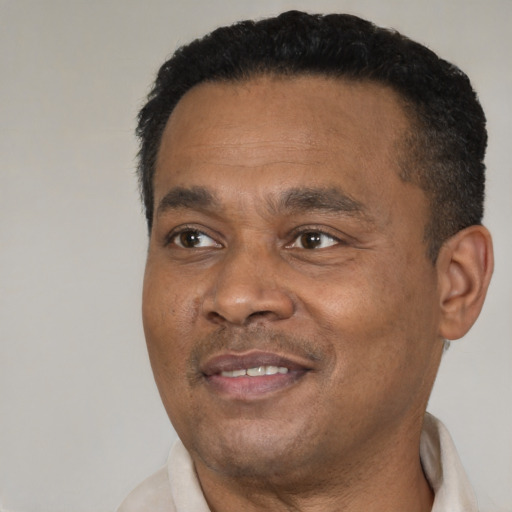 Joyful black adult male with short  black hair and brown eyes