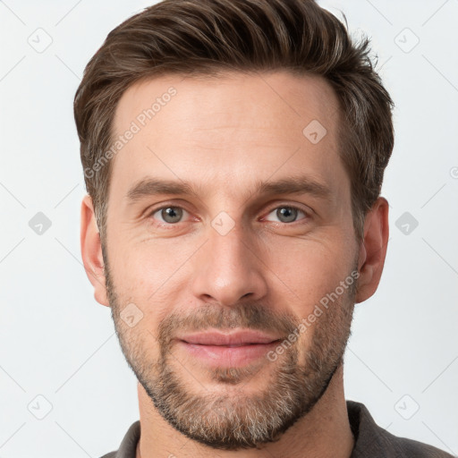 Joyful white young-adult male with short  brown hair and grey eyes