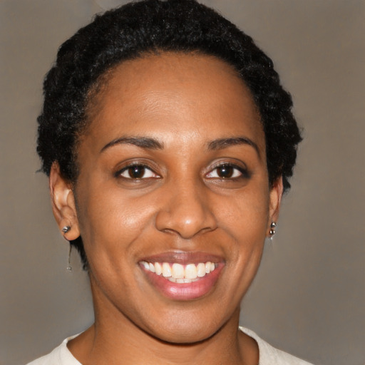 Joyful black young-adult female with short  black hair and brown eyes