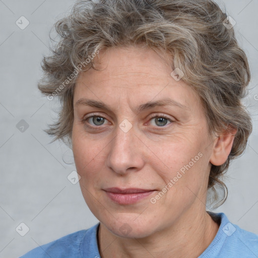 Joyful white adult female with medium  brown hair and blue eyes