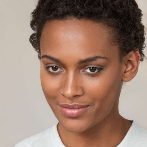 Joyful black young-adult female with short  brown hair and brown eyes