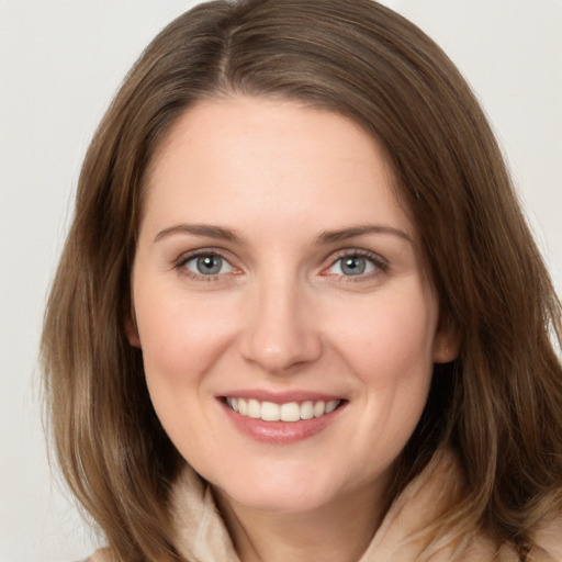 Joyful white young-adult female with long  brown hair and grey eyes