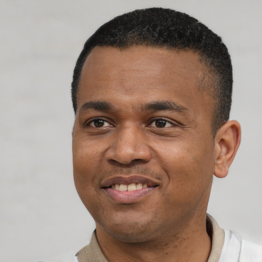 Joyful black young-adult male with short  black hair and brown eyes